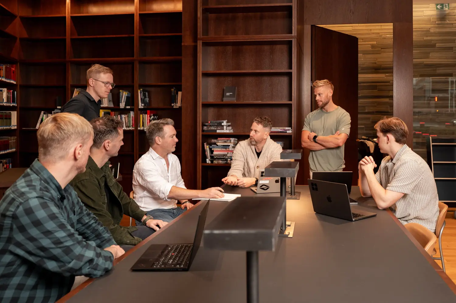 The team sharing ideas and working together around a library table.